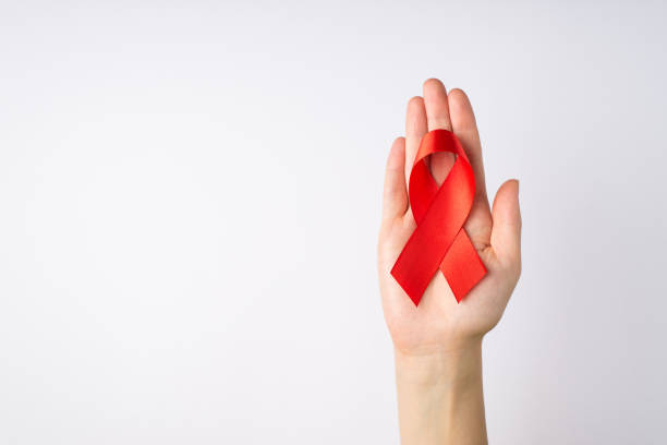 first person top view photo of female hand holding red ribbon in palm symbol of aids awareness on isolated white background with blank space - aids awareness ribbon imagens e fotografias de stock