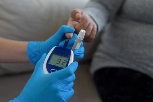 doctor making blood sugar test at home - hypoglycemia imagens e fotografias de stock