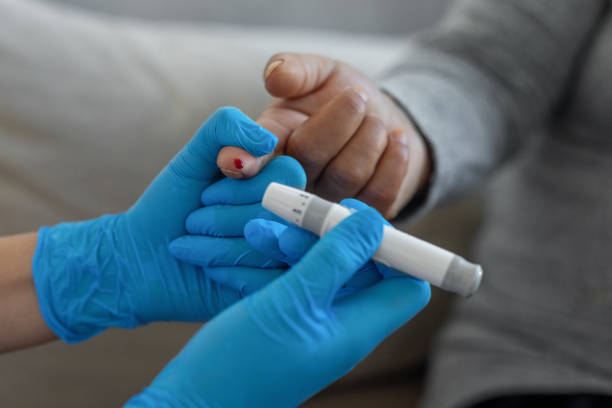 istock A nurse helping a woman a diabetes test 1354271886