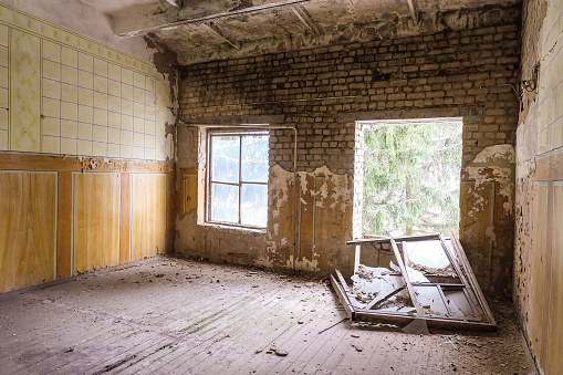 Old ruined tumbled out window inside. Room in abandoned building.