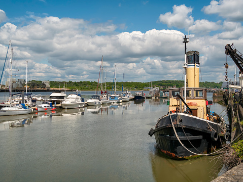 An assortment of boats, mostly leisure craft but also an old tug - moored in the River Medway at Chatham in Kent.