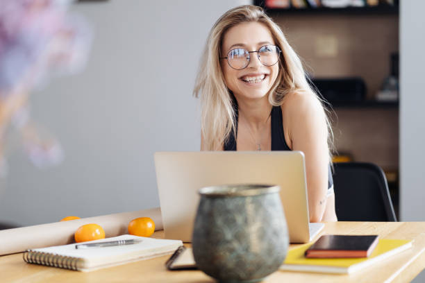 istock Young woman wearing glasses sit at desk watch webinar making notes 1354276198