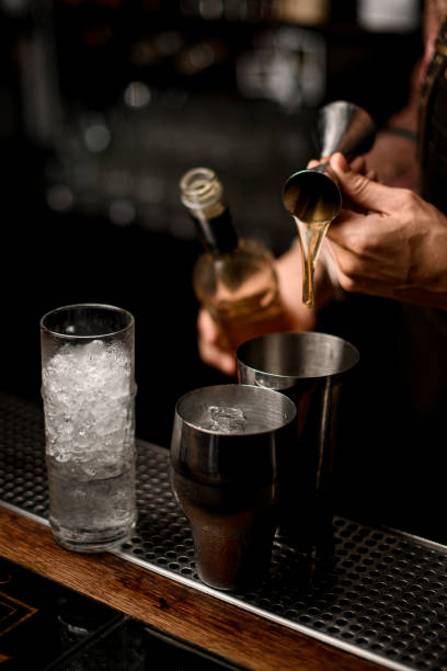 istock hand of bartender masterfully pours drink from jigger into steel shaker glass 1354276453