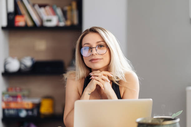 istock Young woman wearing glasses sit at desk watch webinar making notes 1354276483