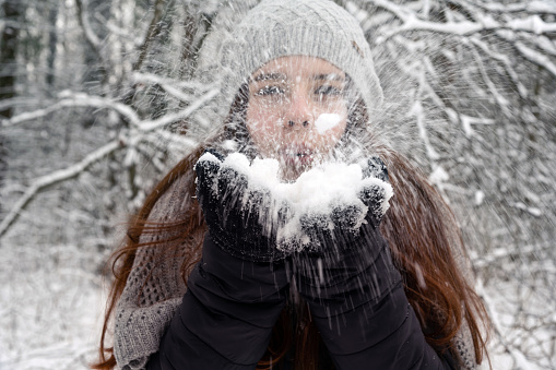 Teenage girl blowing snow away