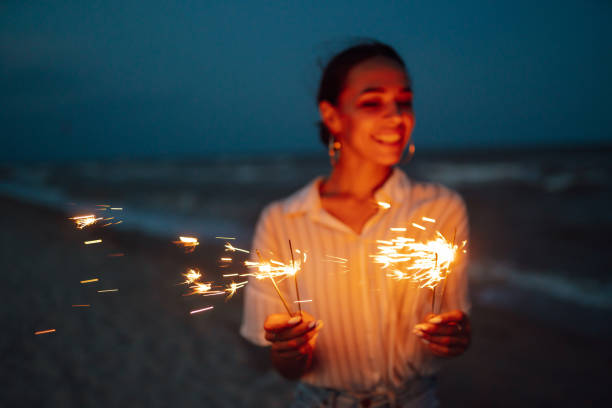istock Female  hand holding burning Christmas sparkle on nature. 1354276592