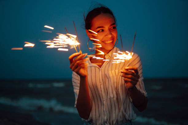istock Female  hand holding burning Christmas sparkle on nature. 1354276597
