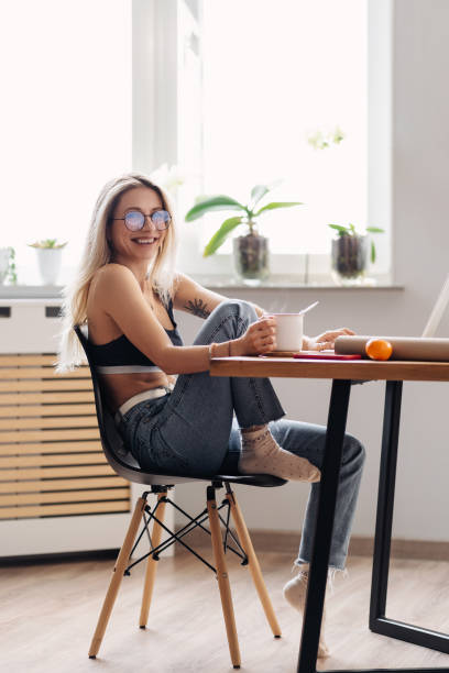 istock Modern girl relaxing at kitchen surfing internet 1354276689