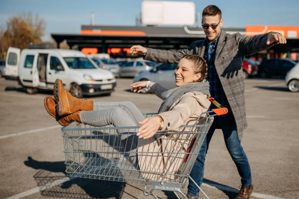 istock Happy couple riding shopping trolley 1354278294