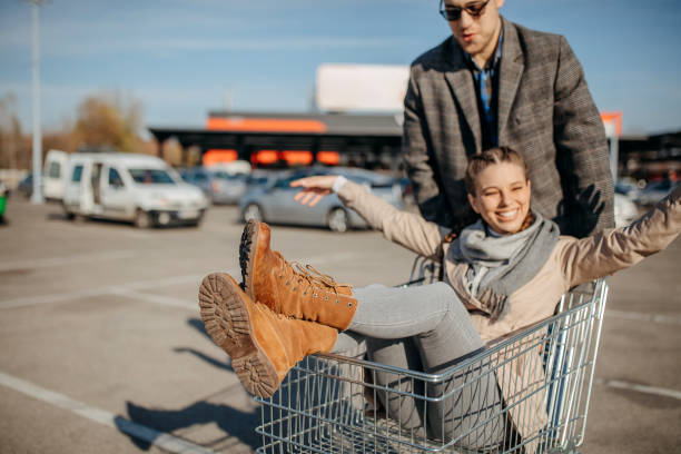 istock Happy couple riding shopping trolley 1354278316