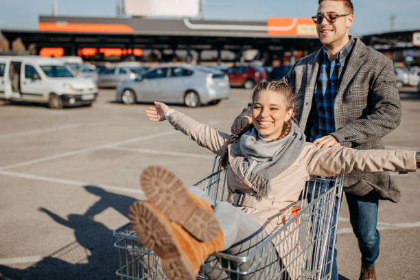 istock Happy couple riding shopping trolley 1354278322