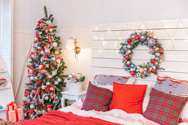 istock Classic interior room with Christmas tree and traditional white red decorations. Modern clean white classical style interior design apartment bedroom. Christmas eve at home. Minimalist home design 1354278543