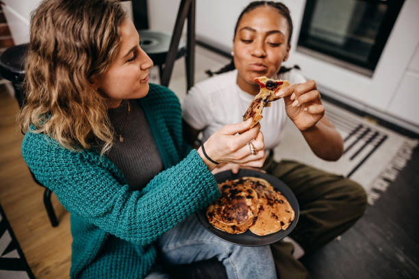Shot of loving young couple in kitchen by breakfast table