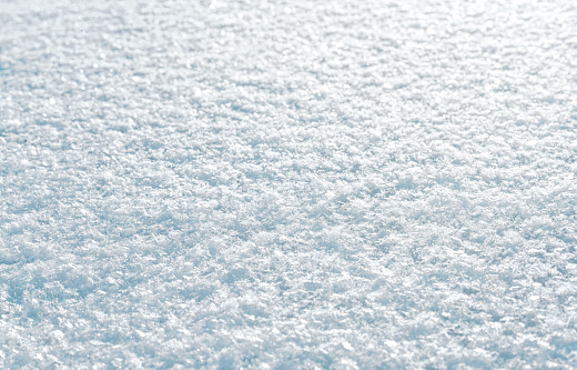 Snow. Background of tight-fitting crystals. Illuminated by the rays of the sun.