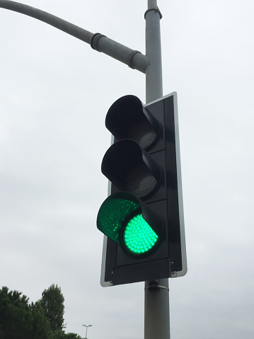 Green color traffic light with sky background