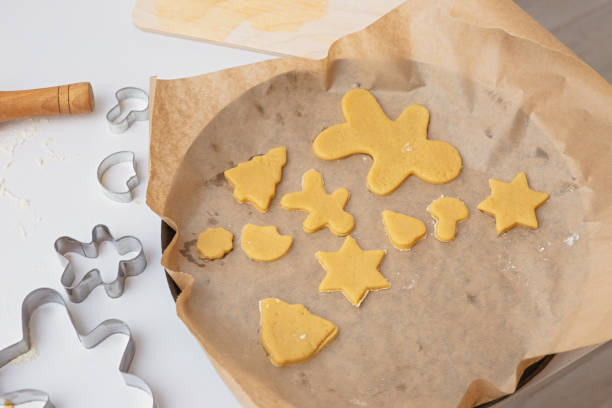 istock Round baking sheet with baking paper and raw Christmas cookies of different shapes 1354292013