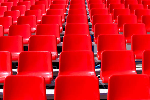 istock Rows of the red plastic chairs in perspective as a background 1354302381