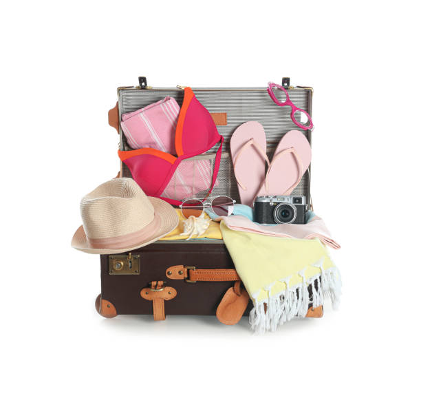 istock Open vintage suitcase with different beach objects packed for summer vacation isolated on white 1354302896