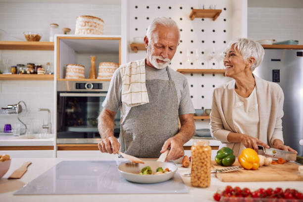 istock An elderly couple having fun in the kitchen preparing healthy food 1354304569
