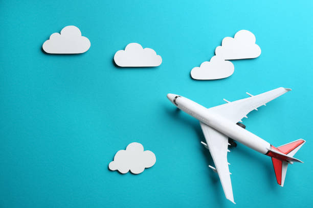 istock Toy airplane and clouds on light blue background, flat lay 1354305562