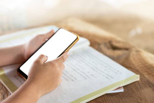 istock Children using mobile phones to open applications for learning. 1354305834