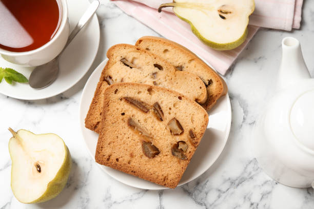 istock Flat lay composition with pear bread on white marble table. Homemade cake 1354305937