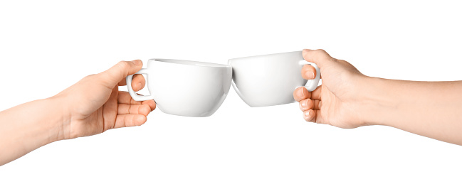Women clinking cups on white background, closeup
