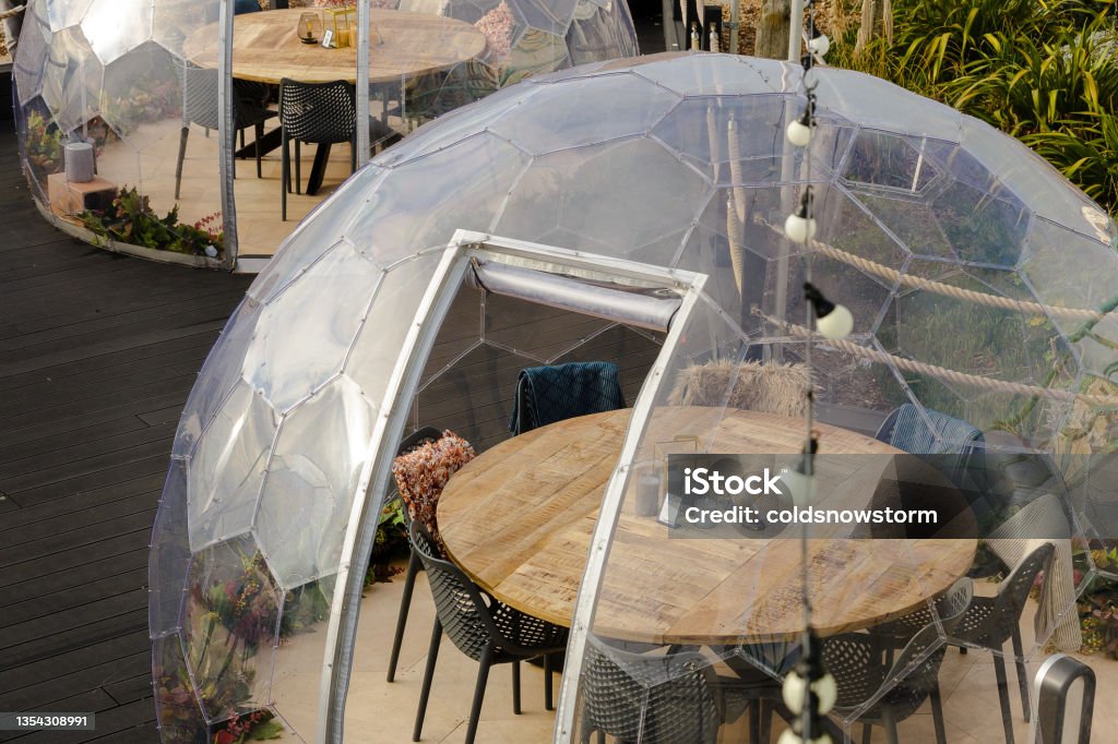 Restaurant pods on terrace outdoors in the city Transparent 'igloo' restaurant pods for a cozy dining experience in the city. Igloo Stock Photo