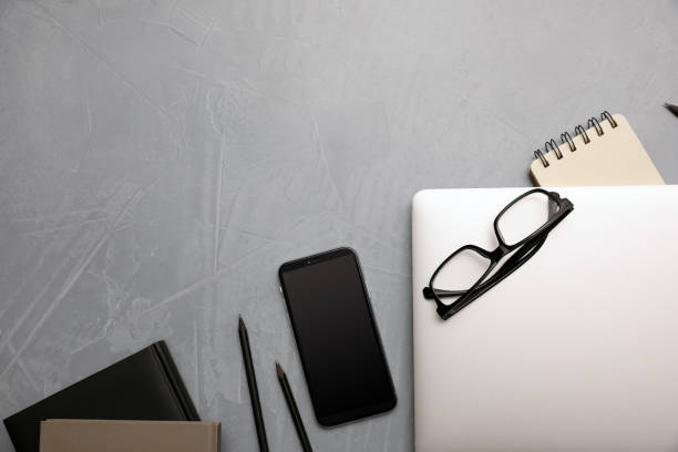 istock Laptop, smartphone and stationery on grey table, flat lay. Space for text 1354309382
