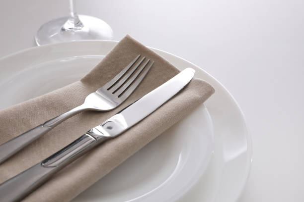istock Elegant cutlery with napkin on white table, closeup 1354310111