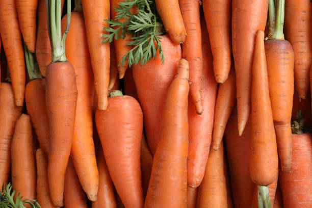 istock Tasty raw carrots as background, top view 1354310480