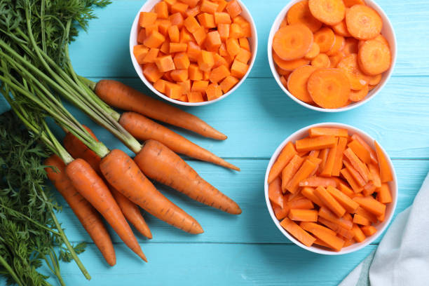 istock Flat lay composition with ripe carrots on light blue wooden table 1354311631