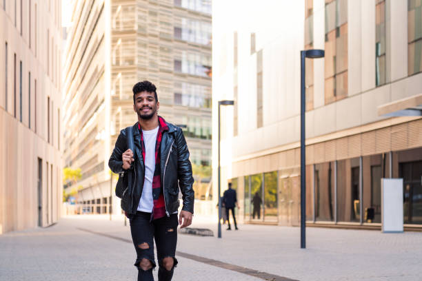 istock young latin man with backpack walking in the city 1354316704