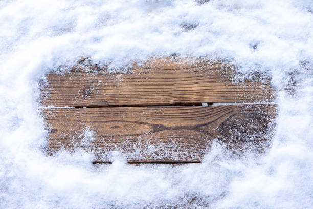 istock Winter background. Empty wooden plank with snow border, copy space for text 1354316961