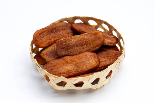 istock Sun dried bananas in bamboo basket on white background. 1354318146