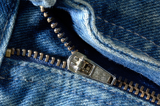 Blue jeans pants zipper, extreme close-up.
