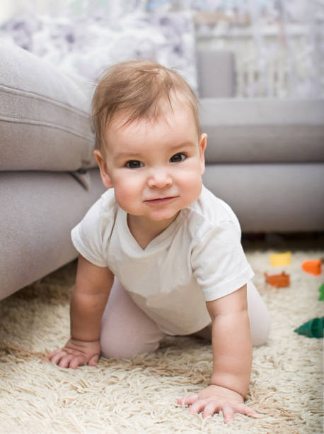 istock A beautiful baby with an interesting emotion on her face is crawling on the floor 1354318936