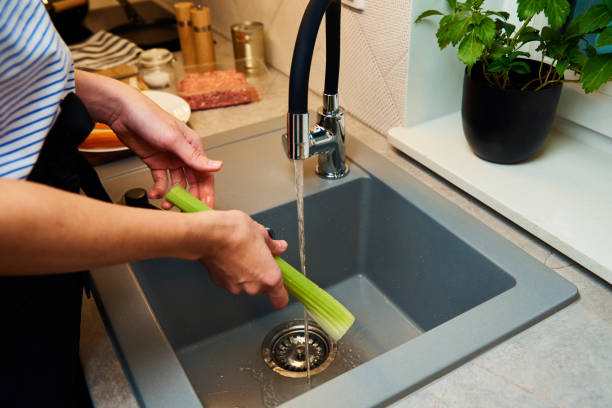 istock Woman wash fresh celery in kitchen 1354324173