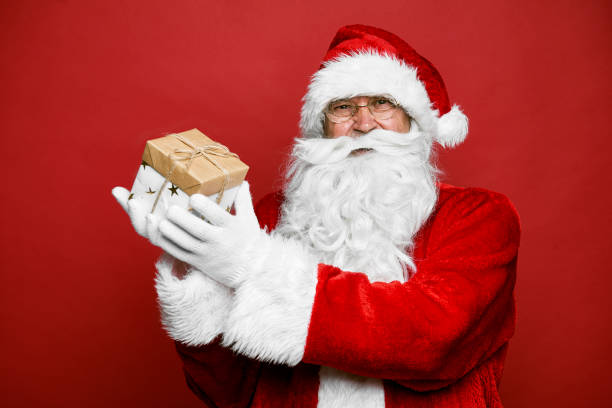 istock Smiling caucasian Santa Claus holding Christmas present 1354328141