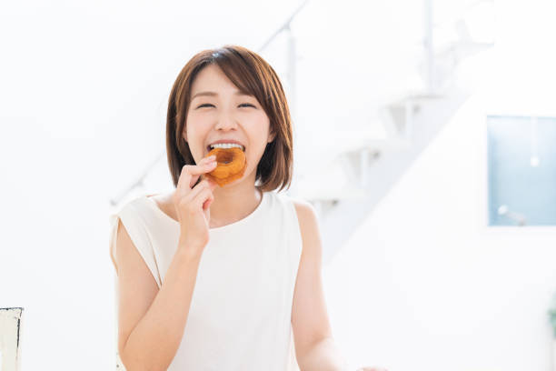 young attractive asian woman eating donuts
