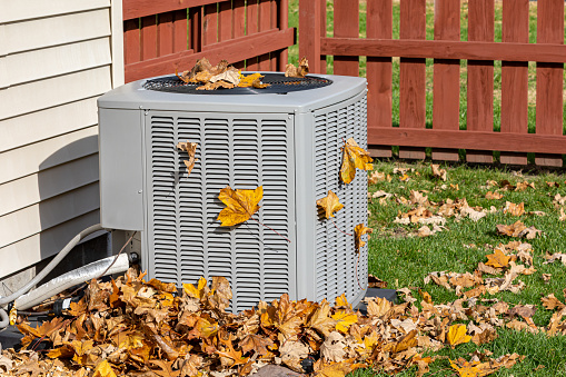 dirty air conditioning unit covered in leaves during autumn home air conditioning hvac repair