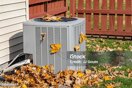 istock Dirty air conditioning unit covered in leaves during autumn. Home air conditioning, HVAC, repair, service, fall cleaning and maintenance. 1354335583