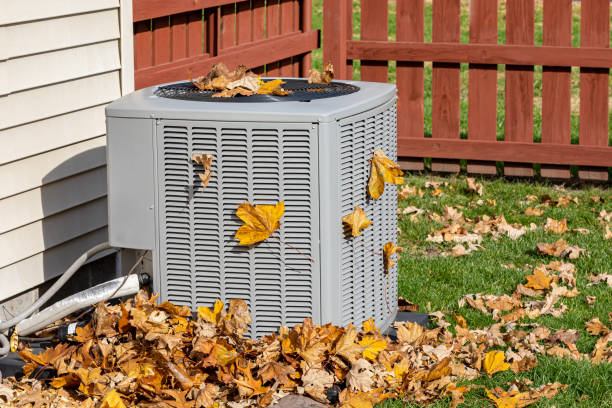 Dirty air conditioning unit covered in leaves during autumn. Home air conditioning, HVAC, repair, service, fall cleaning and maintenance. stock photo