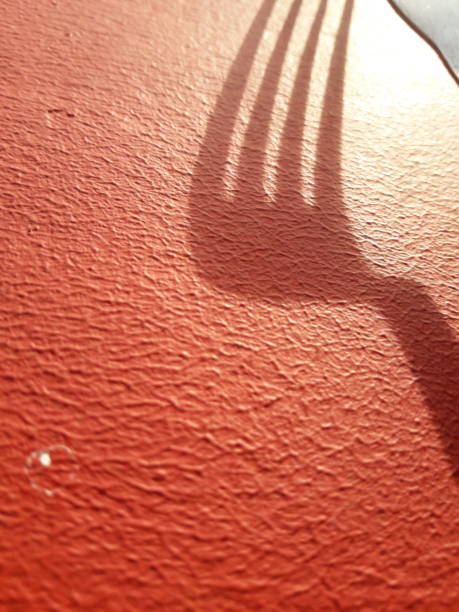istock The fork and its shadow on a red background highlighted by the rising sun 1354336841