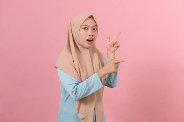 istock Cheerful muslim woman pointing at copy space 1354341810