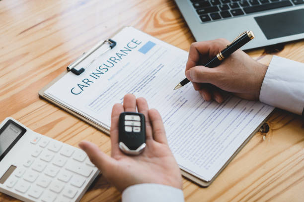 Businessman signing car insurance document or lease paper contract or agreement. Buying or selling new or used vehicle with car keys on table. Businessman signing car insurance document or lease paper contract or agreement. Buying or selling new or used vehicle with car keys on table. auto insurance stock pictures, royalty-free photos & images