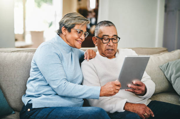 zdjęcie starszej pary korzystającej z cyfrowego tabletu w domu - senior adult senior couple happiness couple zdjęcia i obrazy z banku zdjęć