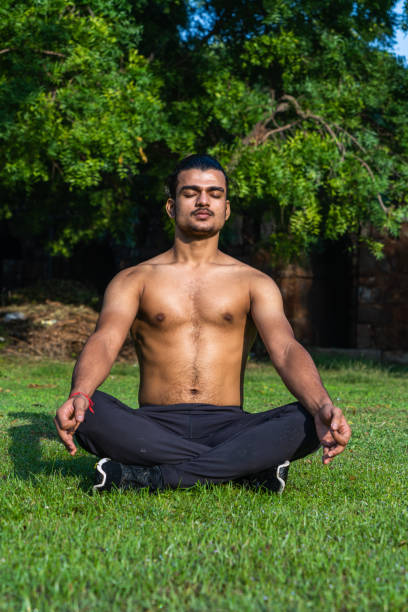 istock young muscular man doing yoga on grass on a sunny day 1354348981