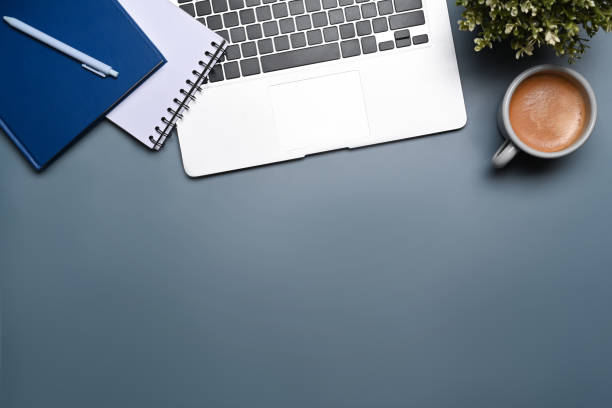 istock Overhead view laptop computer, potted plant, notebook and coffee cup on blue background. 1354350539