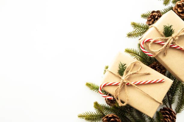 istock Beautiful Christmas background with two gift boxes, decorate with pine branch and pine cone over white background. Top view with copy space, flay lay. 1354359405
